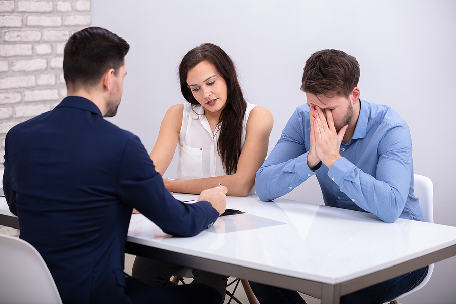 Guardianship in Estate Plan, Rear View Of Financial Advisor Sitting With Depressed Young Couple